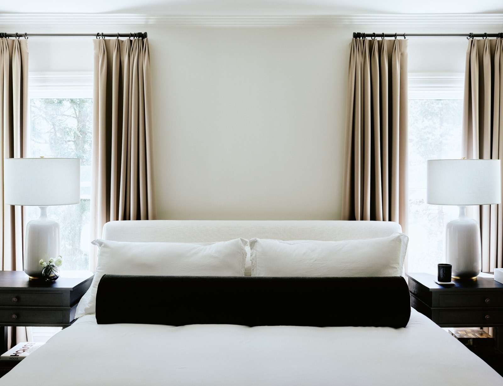 Calm bedroom with symmetrical windows, soft curtains, and crisp white bedding