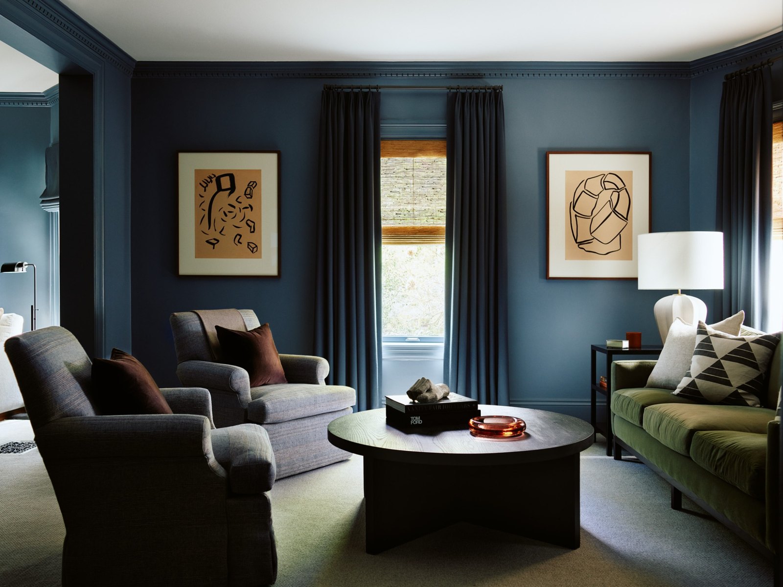 Inviting family room with deep blue walls, upholstered seating, and warm natural light
